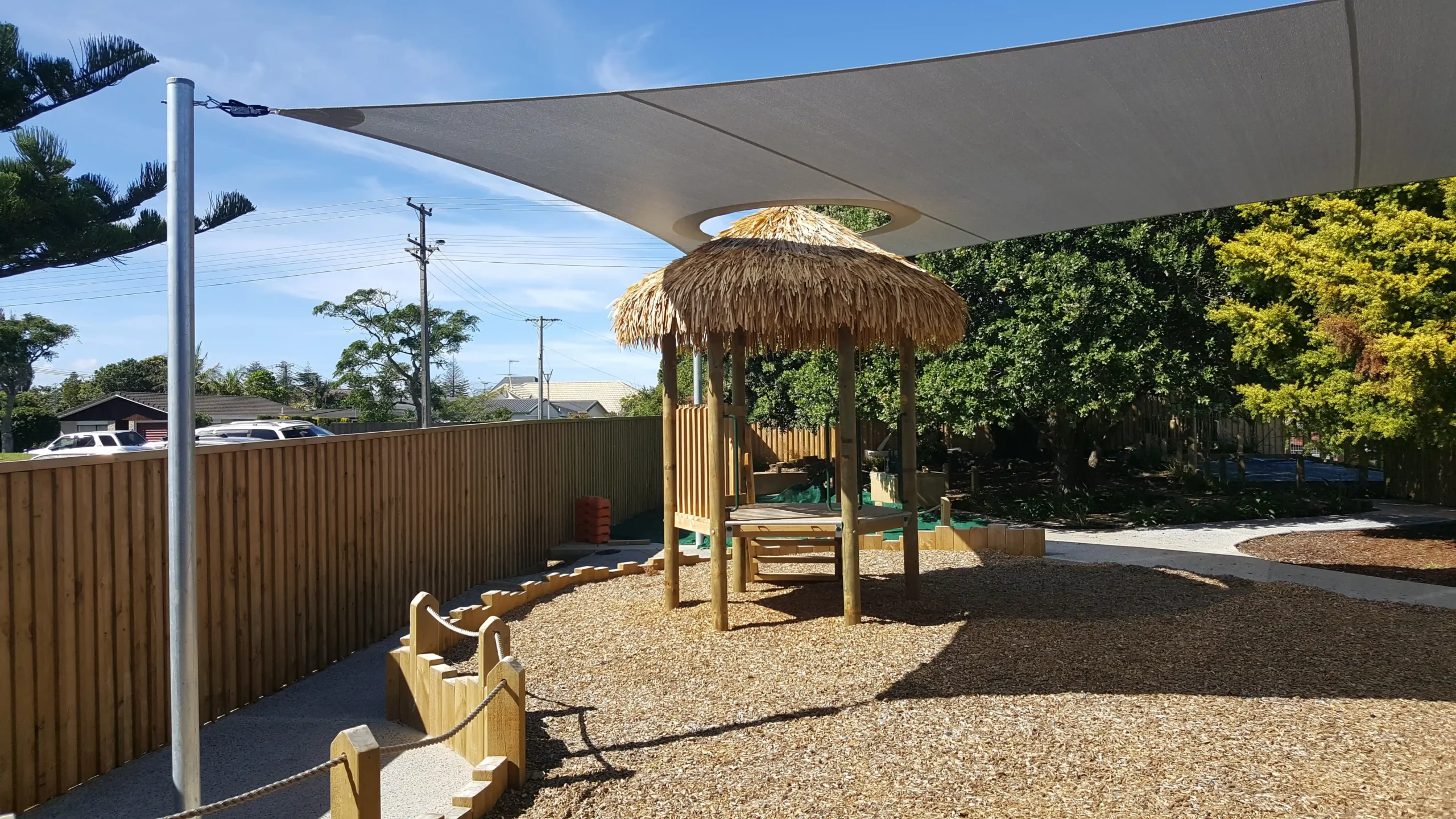 ECE Orewa KiNZ 1 Shade Sail with hole Custom shade sail installed over an early childhood playground area for sun protection and outdoor play