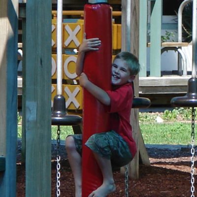 Child hugging shade sail pole pad