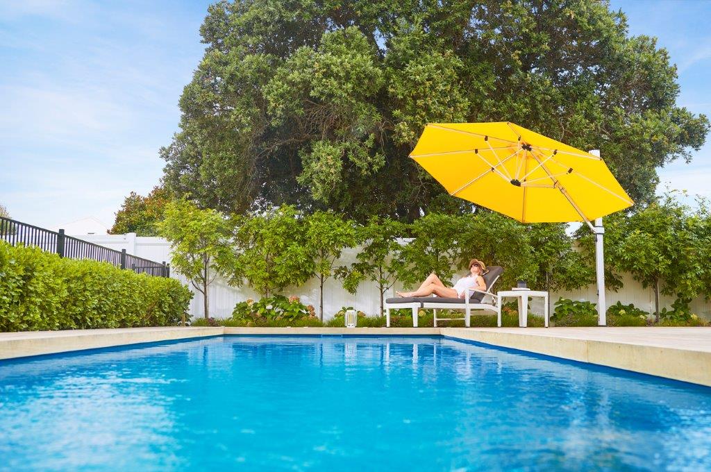 Shade7 Yellow Riviera Cantilever Umbrella - 3.5m Octagonal beside pool