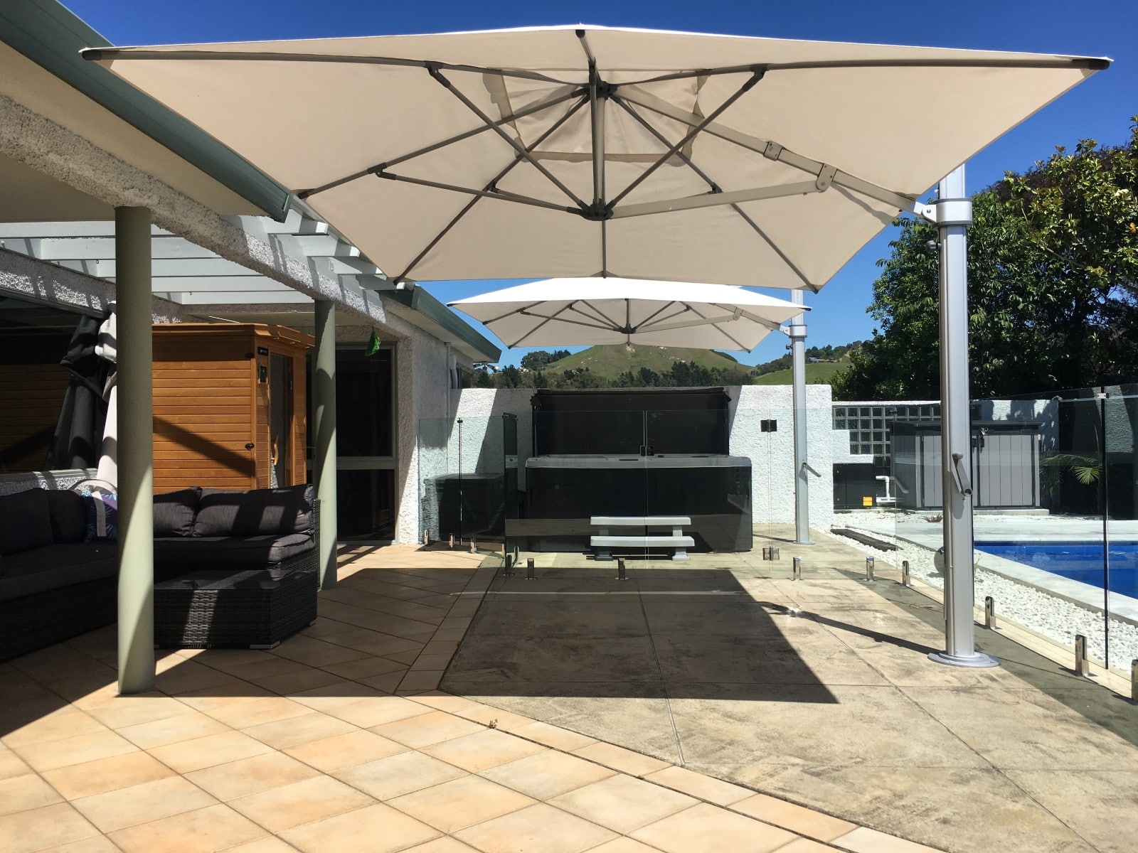 Ultimate shade from two outdoor umbrellas poolside in Hawkes Bay