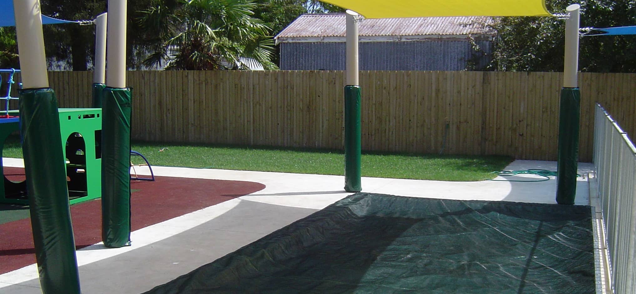 Pole pads under a shade sail at a children's school